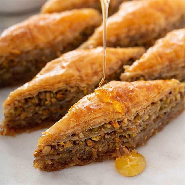 <p><span style="color:#FF0000"><strong>7- Şerbetin Kıvamı:</strong></span></p>
<p> </p>
<p> </p>
<p><strong>- Gerçek baklava:</strong> Hafif ve akışkan bir şerbete sahiptir.</p>
<p>- <strong>Sahte baklava:</strong> Yoğun, yapışkan ve bal kıvamında olabilir. Bu durum, glikoz şurubu kullanıldığını gösterir. Glikozlu baklava ağızda tatlı bir yanma hissi bırakır.</p>
