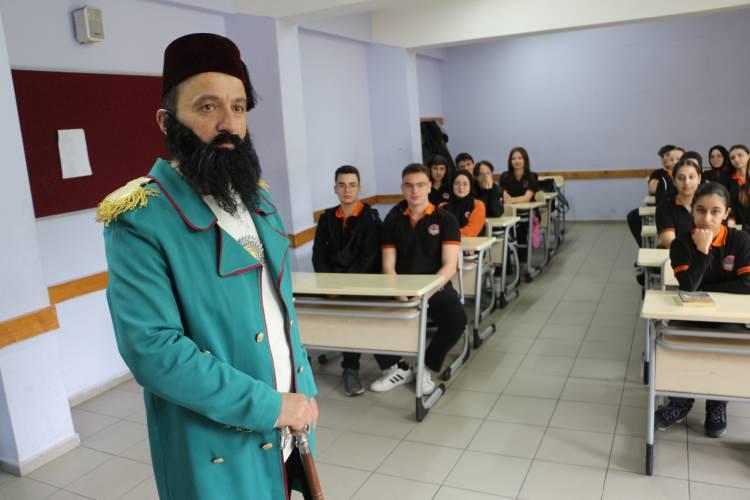 <p>Okur, üzerine giydiği kıyafetler ile o gün anlatacağı tarihi karakterin kılığına bürünerek öğrencilerin karşısına öyle çıkıyor. Öğretmenlerinin derse o şekilde girdiğini gören öğrenciler hem şaşırıyor hem de dersi daha bir dikkatli dinliyor.</p>
