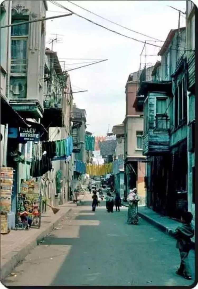 <p>80'lerde Vefa'da renkli çamaşırların asılı olduğu bir sokak</p>