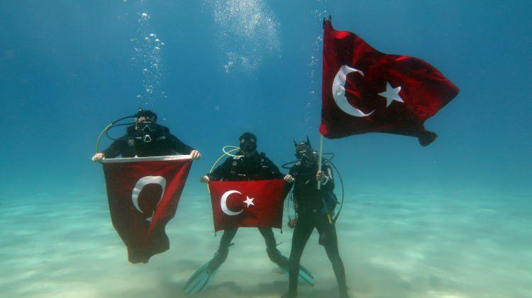 <p>Muğla'nın Fethiye ilçesinde bir grup dalgıç, 19 Mayıs Atatürk'ü Anma Gençlik ve Spor Bayramı'nı deniz dibinde Türk bayrakları açarak kutladı.</p>
<p>İlçedeki bir dalış merkezindeki dalgıçlar, Sarıyarlar Koyu açıklarında 5 metreye dalış yaptı.</p>
<p>Önder Diktaş, Alperen Beyaz, Barış Safran ile Berkay Çetin, su altında "19 Mayıs Atatürk'ü Anma Gençlik ve Spor Bayramı kutlu olsun" yazılı döviz açtı.</p>
<p>Dalgıçlar ayrıca Türk bayraklarıyla temsili "tören geçişi" yaptı.</p>
