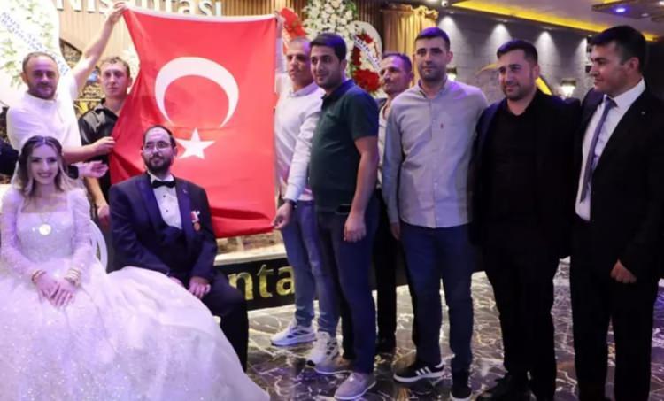 <p><span style="color:#800000"><strong>SİLAH ARKADAŞLARI DÜĞÜNE TÜRK BAYRAĞI İLE KATILDI</strong></span></p>
<p><span style="color:#000000">Damadın silah arkadaşları, düğünün yapıldığı salona Türk bayrağı ve Ali Kınık'ın 'Yalnız değilsin' şarkısı eşliğinde girdi. Yakutiye Belediye Başkanı Mahmut Uçar'ın nikahı kıydığı törene, Aile ve Sosyal Hizmetler Bakan Yardımcısı Zafer Tarıkdaroğlu, Erzurum Vali Yardımcısı Ahmet Özdemir, Aile ve Sosyal Hizmetler İl Müdürü Hasan Aykut, MHP İl Başkanı Adem Yurdagül ile Türkiye Gazileri ve Şehit Aileleri Vakfı Erzurum Şube Başkanı Rıza Demir, çok sayıda gazi ve davetli katıldı.<strong></strong></span></p>