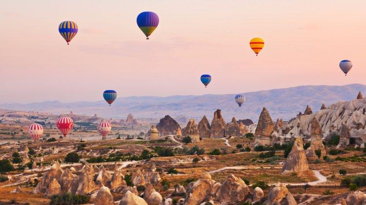 <p>"KAPADOKYA TARAFINDAN FIRLATILMIŞ BİR ANIT GİBİ"</p>

<p>Ortahisar ile ilgili seyahat uzmanları şu bilgilere yer verdi: "Kayısı ve kül rengi çizgilerle bezeli bazalt bir gökyüzünün altında, Ortahisar Kapadokya toprağından fırlamış bir anıt gibi yükseliyor. Taş sokaklar, kayısı tezgahları ve incir ağaçlarının gölgelediği gül kokulu çay bahçelerinin yanından kıvrılarak geçiyor. Yerel halk lale şeklindeki bardaklarla çay içerken hikayeler paylaşıyor. Bu arada, gündoğumu balonları Hallacdere Vadisi'nin gerçeküstü sivri kayalarının üzerinde sessizce süzülüyor. Etnografya Müzesi'ni mutlaka ziyaret edin."</p>

<p> </p>
