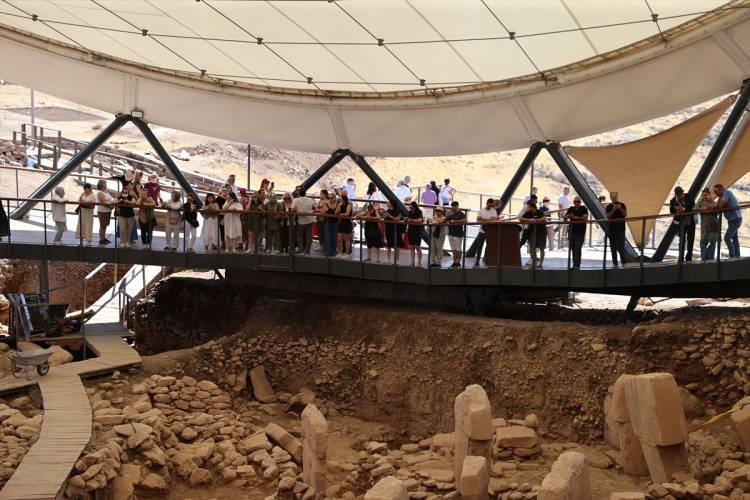 <p><span style="color:#B22222"><strong>YAPILAR HÖYÜĞÜN DOĞU VE GÜNEYNDE YOĞUNLAŞIYOR</strong></span></p>

<p> </p>

<p>Bölgede kısa sürede önemli sonuçlar elde etmenin mutluluğunu yaşadıklarını dile getiren Karul, şöyle devam etti:</p>

<p> </p>

<p>"Bugüne kadar Göbeklitepe'de sekiz anıtsal yapı açığa çıkarıldı. Yine jeomanyetik ölçümlerle varlığından haberdar olduğumuz alanlar vardı. Biliyorsunuz, bu yılın başında höyüğün neredeyse tamamını kaplayan zeytin ağaçlarını taşımıştık. Bu sayede hem ölçüm yapma olanağı bulduk hem de ileriki yıllar için kazı hazırlığı yapmış olduk. İlk sonuçlarda, Göbeklitepe'den bildiğimiz büyük anıtsal yapıların benzerlerinin yanı sıra daha önce çok az bildiğimiz konut niteliğinde olabilecek dörtgen planlı yapıların varlığını tespit ettik. Bu yapılar özellikle höyüğün, yani kazısı yapılmış alanların doğu ve güney bölgelerinde yoğunlaşıyor.</p>
