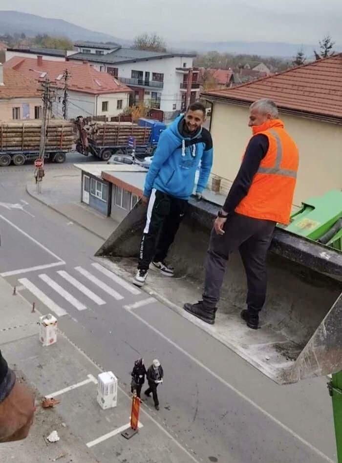 <p>Bir kepçe üzerindeki iki işçi, kamera açısı nedeniyle dev gibi görünüyor.</p>
<p></p>