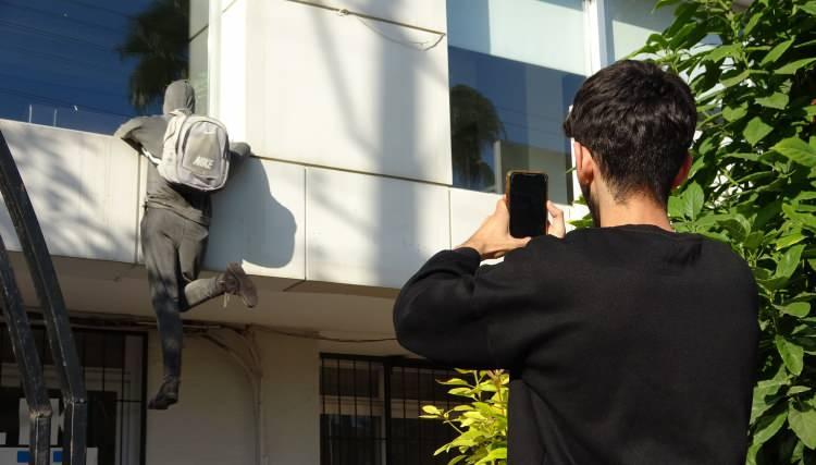 <p>Şirket yetkilileri yaklaşık 5 yıl önce binanın 1. katındaki pencereye, sırt çantalı ve kapüşonlu bir hırsızı andıran cansız manken yerleştirdi. Vatandaşları hırsızlığa karşı bilgilendirme ve sigorta yaptırmaya yönlendirme amacıyla yerleştirilen manken, aradan yıllar geçmesine rağmen hala birçok kişinin dikkatini çekiyor. </p>
