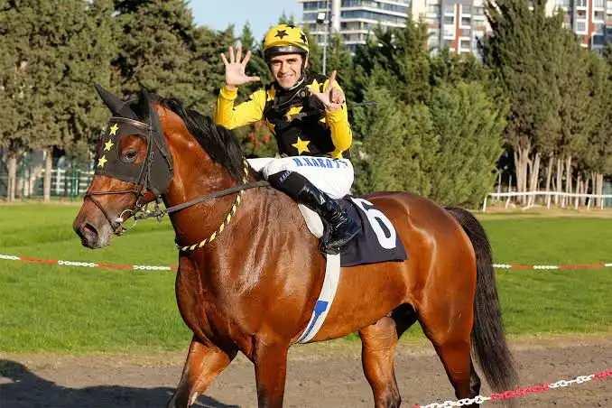 <p><span style="color:#800080"><strong>1- HALİS KARATAŞ</strong></span></p>

<p>&nbsp;</p>

<p>T&uuml;rkiye'nin bir numarlı jokeyi <strong>Halis Karataş</strong>, <strong>2 Ocak 2025</strong> tarihinde Veliefendi Hipodromu'nda d&uuml;zenlenen bir yarışta atının kontrolden &ccedil;ıkması sonucu ciddi bir kaza ge&ccedil;irdi. Kaza sonrası hastaneye kaldırılan Karataş, yapılan kontrollerin ardından taburcu edilerek sağlık durumunun iyi olduğu belirtildi.</p>
