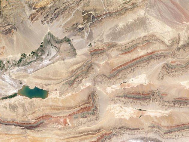 <p><strong>&Ccedil;İN</strong></p>

<p>G&ouml;r&uuml;nt&uuml;n&uuml;n ortasına dikkatle bakarsanız, fotoğrafı kuzeyden g&uuml;neye kesen şeffaf bir &ccedil;izgi fark edeceksiniz. Bu &ccedil;izgi, &Ccedil;in'in Tien Shan dağlarında yer alan Piqiang fay hattını temsil ediyor. Fay hattının, batıdan doğuya ilerleyen renkli araziyi nasıl yukarı &ccedil;ektiği rahatlıkla g&ouml;r&uuml;lebiliyor.</p>
