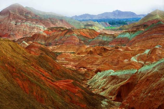 Usta bir ressamın ellerinden çıkmış yağlı boya tabloları andıran bu kareler aslında üzerinde ufak bir oynama bile olmayan fotoğraflar. Çin’in Gansu eyaletindeki Niciaying kasabasının Nantaizi köyünde bulunan bu tepelerin her şeyi doğal. Kırmızı kumtaşı katmanlarından oluşan bu arazi zaman içinde dik yamaçlar ve benzersiz kaya oluşumlarından meydana gelen dağlık bir araziye dönüşmüş. Bu tarz bir kaya oluşumu sadece Çin’de bulunuyor.