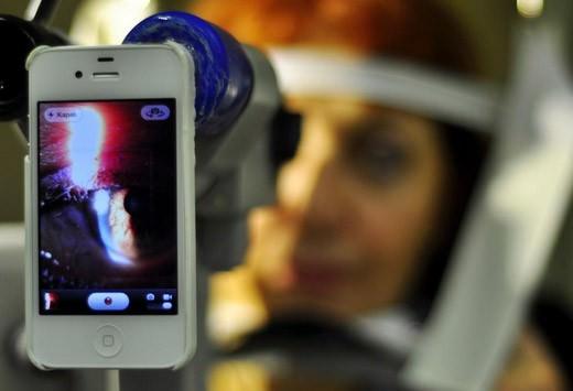 Göz hastalıkları uzmanı Doç.Dr. Hüseyin Yetik akıllı telefon için geliştirdiği özel ekipman ile göz muayenesi yapıyor.