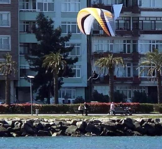 Taşbaşı Mahallesi üzerinden süzülerek sahilde yürüyüş yoluna inmek isteyen Alp, rüzgarın etkisiyle kontrolünü kaybedince kayalıklara çarparak denize düştü.