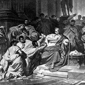Julius Caesar - Julius Caesar (12 Temmuz, M.Ö. 100 - 15 Mart, M.Ö. 44), Romalı general ve en bilinen Roma İmparatorlarındandı. Ülkesinde önce sevilen ama daha sonra bir tiran olarak anılan Caesar'a birçok kesimden nefret nidaları yükselmekteydi. Caeser Galya'ya gidip birkaç yıl süren bir savaşla (58'den 51'e kadar) bütün ülkeye boyun eğdirdi; Galyalıların ayaklanmasını bastırdı ve bu arada Vercingetorix'in örgütlediği genel isyanı bastırdı. Bu uzun savaşı, "Galya Savaşı Üstüne Yorumlar" adlı eserinde, kendisi anlatacaktır. Sezar askerleri yönetmeyi biliyor, onlar da, kendi çetin koşullarını ve yorgunluklarını paylaşmaktan geri durmayan bu komutana değer veriyorlardı. Ama Roma'daki şöhreti, senatoyu ve özellikle iktidarı kendi başına yürütmek sevdasında olan Pompeius'u kaygılandırmaktaydı. Bunu anlayınca Sezar meşruluk dışına çıkmağa karar verdi: askerleriyle Rubico Irmağı'nı aşıp şehre yürüyerek iç savaşı başlattı. Pompeius Yunanistan'a kaçtı, orada, 48 yılında Pharsale'de yenilgiye uğradı, taraftarları ise Afrika ve İspanya'da darmadağın edildiler, kılıçtan geçirildiler. 45 yılında iç savaş sona erdi. Zaferi kazanan Sezar, artık mutlak hükümdar olarak ülkeyi yönetebilecekti. Diktatör, ömür boyunca konsül ve en yüksek majistra seçildi. Kuruluşlarda derin bir reforma girişti. Bir yıl içinde cumhuriyeti imparatorluğa dönüştürdü. Yerine geçecek varisi olmadığından, yeğeninin oğlu, müstakbel Augustus olacak Octavius'u evlât edindi. Ama düşmanları ona karşı, himayesindeki Brutus ve Cassius yönetiminde bir suikast hazırladılar. Sonunda senatoda, Pompcius'un heykelinin dibinde üvey oğlu Brutus tarafından hançerlenerek öldürüldü.