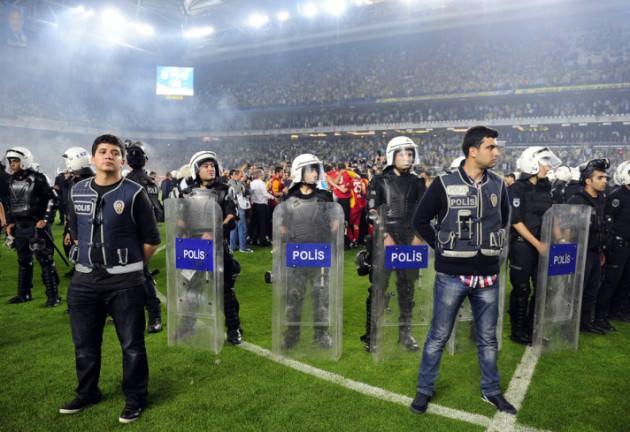 Kale arkasında bulunan tribünlerden aniden yeşil çimleri üzerine giren taraftarların saha kenarında bulunan yayıncı kuruluş kameralarını da kırdıkları gözlendi. 