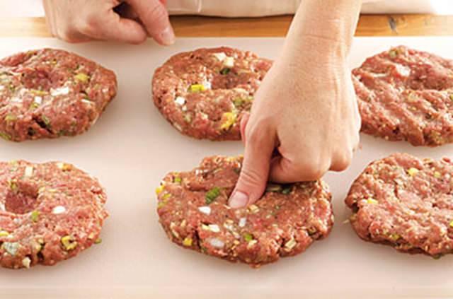 <p>Hamburger köftesinin şişmeden pişirmek için ortasına çukur açın.</p>