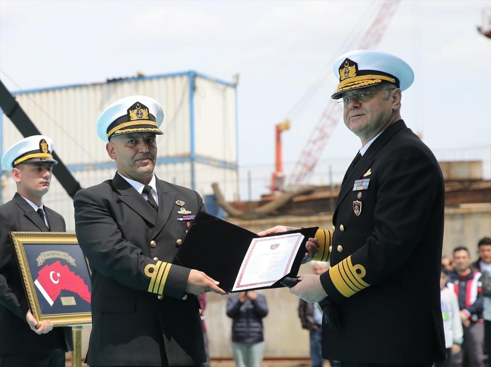 <p>Oramiral Bülent Bostanoğlu (sağda), Gemi Komutanı Binbaşı Bülent Güngör'e geminin hizmete giriş belgesini teslim etti.</p>