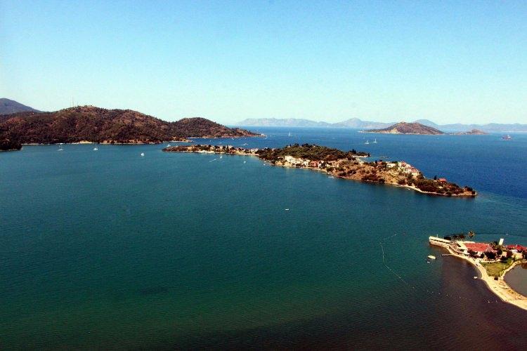 <p>Türkiye'nin cennet köşelerinden Fethiye Körfezi, açık denize kapalı dikdörtgen yapısı nedeniyle derelerin taşıdığı çamurdan olumsuz etkileniyor. Körfez, her geçen yıl çamurla dolarken denizde oluşan kirlilik artık gözle görülebiliyor. Helikopterle havadan çekilen fotoğraflar, deniz içinde oluşan çamur tepelerini gözler önüne serdi. Körfezdeki teknelerin çamura saplanmamak için belli rotalarda zikzaklar çizerek ilerleyebildiği belirtildi.</p>
<p> </p>