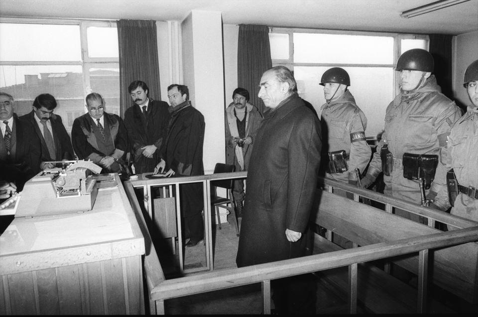 <p> MHP Genel Başkanı Türkeş, 30 Ekim 1978'de Almanya'nın Dortmund kentinde yaptığı salon toplantısında söylediği sözlerle hükümete hakaret ettiği gerekçesiyle 15 Aralık 1980'de Ankara Ağır Ceza Mahkemesinde yargılanırken görülüyor. </p>
