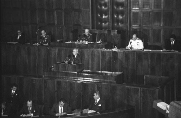 <p> Başbakan Bülend Ulusu eski Cumhuriyet Senatosu genel kurul salonunda hükümet programını okudu. Toplantıyı Devlet Başkanı, MGK ve Genelkurmay Başkanı Orgeneral Kenan Evren (üstte ortada) yönetti. MGK Genel Sekreteri Orgeneral Haydar Saltık (sol 2) Meclis Kanunlar Müdürü Orhan Dülgerler (sağda)</p>