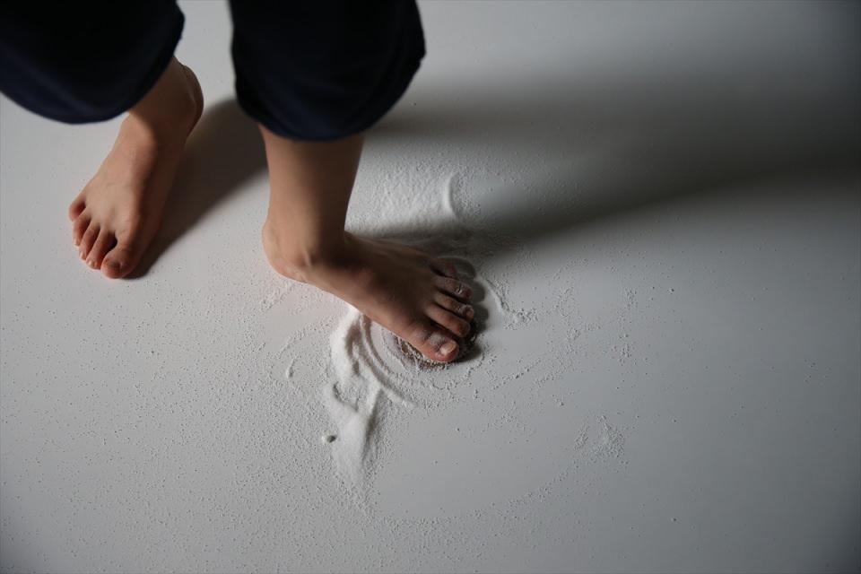 <p>Semazen adayı, çıplak ayakla tahtanın yanına gelip, secde pozisyonunda, "eyvallah" anlamında çiviyi öpüyor. Bir miktar tuzu, parmaklarının arasını pişirmesinin ve yara olmasının önlenmesi amacıyla çivinin bulunduğu yere döken aday, ayağa kalkıp, sol ayağının baş parmağı ile yanındaki parmağının arasına talim çivisini yerleştirip dönmeye başlıyor.</p>
<p> </p>