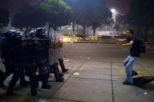 <p><strong>Brezilya’daki yolsuzluk ve polis şiddetine karşı başlatılan protesto gösterilerinde bir protestocu, polislerin önünde.  - 2013</strong></p>
