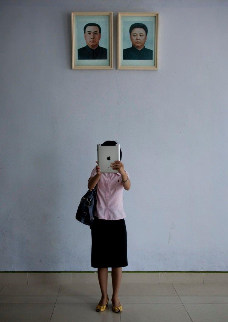 <p>Kuzey Kore Devlet Başkanı'nın fotoğrafıyla elindeki ipad ile selfie yapan bir Koreli bayan.</p>