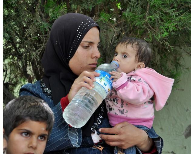 uriye'de yaşanan çatışmalar nedeniyle yanlarına   aldıkları birkaç parça eşyayla Asi Nehri'ni derme   çatma sandallarla aşarak Türkiye'ye sığınan Suriyeliler,   Altınözü ilçesinde bir cami avlusuna sığındı
