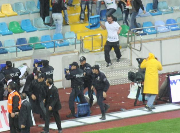Taraftarlar yerinden söktükleri sandalyeleri polisin üzerine fırlattı. Bir taraftarın polisin kafasına sandalye ile vurması objektife yansıdı.