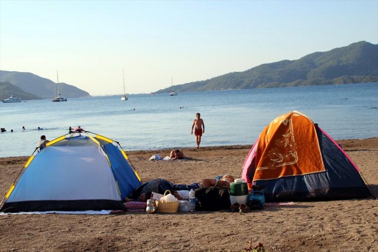 <p>Otel, pansiyon ve kiralık evlerin tamamen dolduğu köyde, tatilciler plaja kurdukları çadırlarda, şezlongların üzerinde veya araçlarında yatarak sabahlıyor. Özellikle marketlerde uzun kuyruklar oluşurken, tatilciler duş ve tuvalet ihtiyaçlarını karşılamakta güçlük çekiyor. </p>