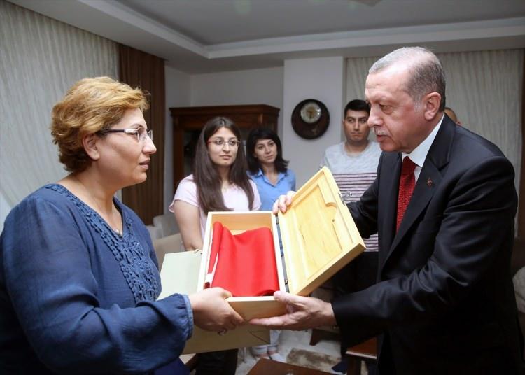 <p>Erdoğan, şehit Kemal Tosun'un eşi Zuhal Tosun'a Türk bayrağı ve Kur'an-ı Kerim teslim etti.</p>