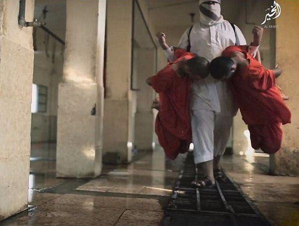 <p>Bir başka dikkat çeken karede, yüzü kapalı bir DAEŞ teröristi kolları arkadan kelepçelenmiş iki esiri dirseklerinden 'hayvan' gibi tutarak vahşetin sergilendiği odaya taşıyor.</p>