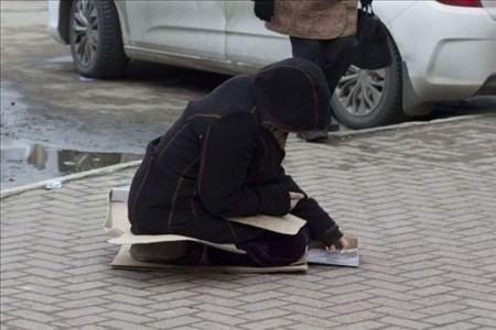 <p>Yoldan geçen insanların para verdiği kadın, kutunun içindeki paralarını saydıktan sonra...</p>
<p> </p>