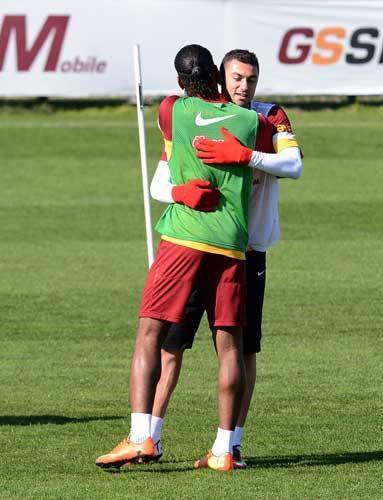 İki oyuncu antrenmandaki molada birbirleriyle neşeli bir şekilde sohbet ederlerken, ardından şakalaşarak birbirlerine sarıldılar.