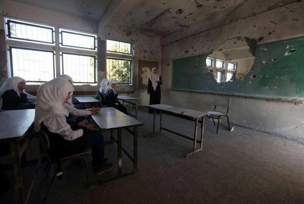<p>Öğrencilerin İsrail saldırılarında hasar gören sınıf tahtasında ders gördüğü kare.</p>
