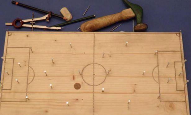 <p>Tahtaya çakılmış çivilerle futbol oyunu</p>
