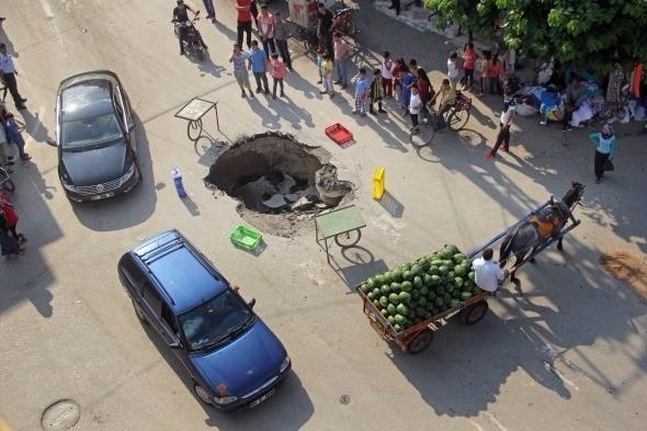 <p>Adana’da şiddetli yağmurun ardından yol ortasında oluşan çukura yayaların ve araçların düşmemesi için vatandaşlar belediye ekipleri gelene kadar simit aracı ve meyve-sebze kasalarıyla önlem aldı.<br />
<br />
Fotoğraf: Fatih Keçe</p>