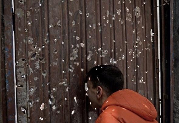 <p>Diyarbakır’ın Bağlar ilçesinde sona eren yasağın ardından bölgede hayat normale döndü. Çatışmaların yoğun olarak gerçekleştiği Kaynartepe’de mermilerin delip geçtiği evinin kapısından içeriye bakan bir çocuk.</p>
