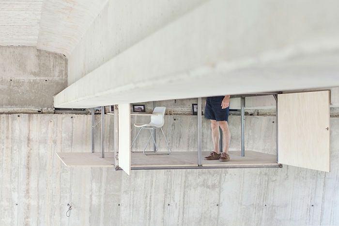 <p>Fernando Abellanas, masa ve sandalye dahil olmak üzere tüm ofis eşyalarını, köprünün beton duvarına monte ederek, tekerlekli zeminin hareket etmesiyle stüdyosuna inip çıkabiliyor.</p>
