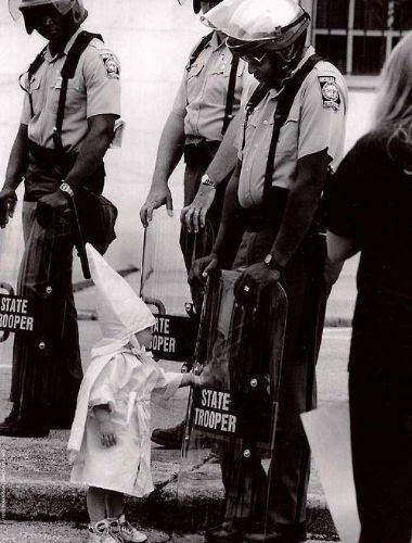 <p><strong>Irkçı radikal örgüt Ku Klux Klan üyelerinden birinin çocuğu, örgütün protestolarından birinde hazır bulunan siyahi polislerden birinin kalkanı ile oynuyor. Küçük çocuğun orada ne için bulunduğu ya da ailesinin siyah insanlara karşı nefreti konusunda bir fikri yok gibi...</strong></p>
