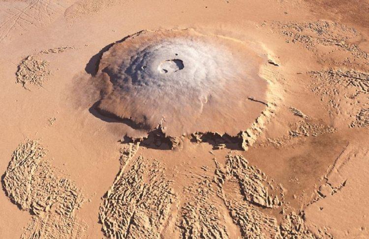 <p>Mars’ta 21 km yüksekliğinde “Olympus Mons” adında bir volkanik dağ bulunmaktadır. O kadar yüksek bir dağ ki Mars’ın kendi atmosferini delip geçiyor. Ayrıca 550 km genişliğine sahiptir.</p>
