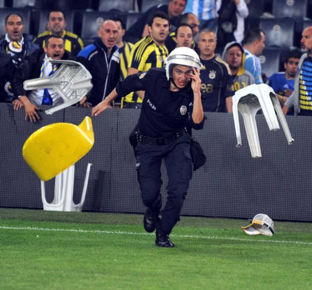 Fenerbahçe-Galatasaray maçı sonrasında olaylar çıktı Spor Toto Süper Final Şampiyonluk Grubu'nun 6. ve son haftasında Fenerbahçe ile Galatasaray, şampiyonun belirleneceği maçta karşı karşıya gelmiş, maç sonunda olaylar çıkmıştı. Bir polisin kendisine atılan sandalyelerden kaçışı objektiflere böyle yansımıştı.