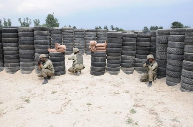 <p>Fotoğraflarda komando timlerinin çatılardan ve kapılardan göz yaşartıcı bomba eşliğinde ev maketlerine girdiği görüldü.<br />
 </p>
