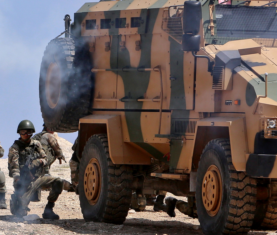 <p><strong>"VATANINA GÖZ DİKENİ EZ OĞUL" EŞLİĞİNDE TATBİKAT</strong><br />
</p>
<p>Tatbikatta barakalar ve binalar şeklinde oluşturulan alana, komandolar Sikorsky tipi helikopterle iniş gerçekleştirdi. Çabuk iniş taktiğiyle hava hücum harekatı icra eden komandolar, Kirpi ve Kobra tipi araçlarla, ‘Vatanına Göz Dikeni Ez Oğul’, ‘Ölürüm Türkiyem’ gibi şarkılar eşliğinde operasyon gerçekleştirdi. Senaryo uyarınca temsili teröristlerin gizlendiği ve birçok noktaya bombalı tuzak kurulan binaların olduğu alana giriş yapıldı. Komandolar, teröristlerin gizlendiği binalara giriş yapmadan önce askeri araçlardan teslim olmaları yönünde çağrıda bulundu.</p>