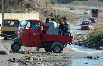 <p>TRİPORTÖR: Bunlar, adından da anlaşılacağı gibi (three / tri: üç) 3 tekerlekli ve direksiyon yerine gidonla kumanda edilen çok enteresan taşıma araçlarıydı. Ağırlıklı olarak; “Arçelik” marka olan triportörlerin sürücü kabinini önünde tek bir tekerleği vardı. Bu tekerlek gidona bağlıydı. Sürücü kabinin tam ortasına otururdu, yanında da sağlı sollu birer kişinin oturabileceği yer kalırdı. Eni normalden daha dar olduğundan ötürü, tek bir farı ve yine tek bir sileceği bulunurdu. Çalışırken çıkardığı sesler, bir motosikletin sesiyle aynı tınıyı verirdi. Bu araçların arkasındaki kasaları, kimi modellerde açık, kimilerinde tenteyle örtülü, kiminde ise metal örtüyle kapatılmış olurdu. PTT’nin araç kadrosunda, arkası kapalı çok sayıda sarı renkli triportör 1980’lerin ortalarına kadar hizmet verdi. Bunlar daha çok posta ve telgraf taşıma işlerinde kullanılırlardı.</p>
