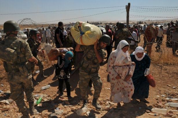 <p>Suriyelilerin eşyalarını taşıyan Türk askerlerinin, yaşlı ve çocuklara şefkati dikkat çekiyor.</p>
