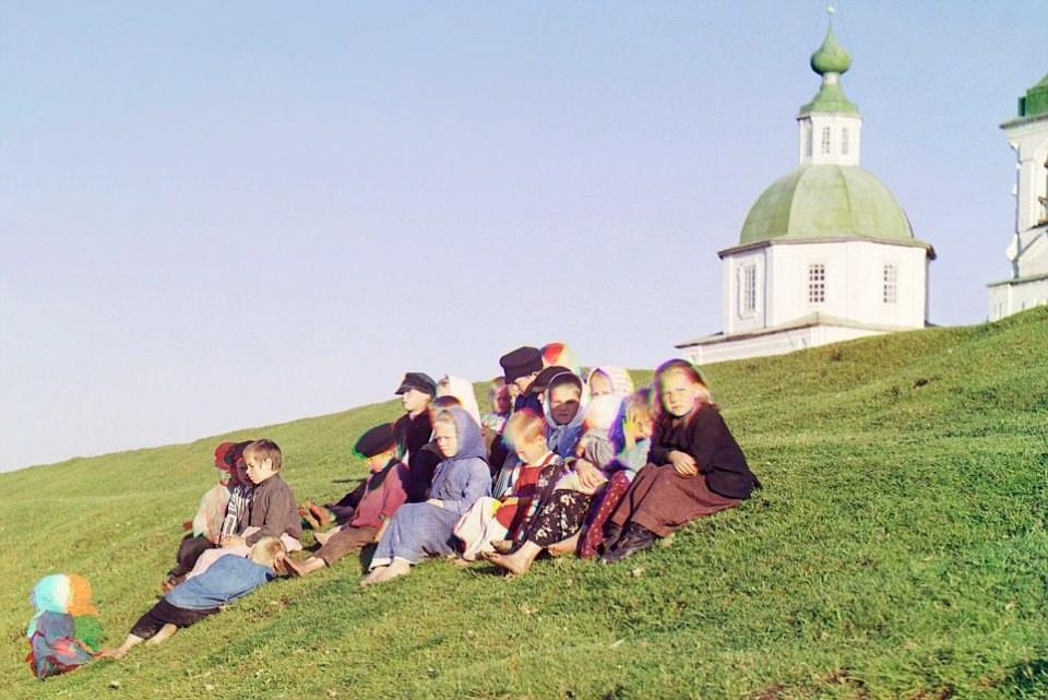 <p>Rusya’da 1909’da çekilen fotoğrafta, Rus çocuklar bir kilise ve çan kulesi önünde oturuyor.</p>