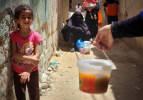 Filistinliler Gazze'de bir kap sıcak yemek için sırada
