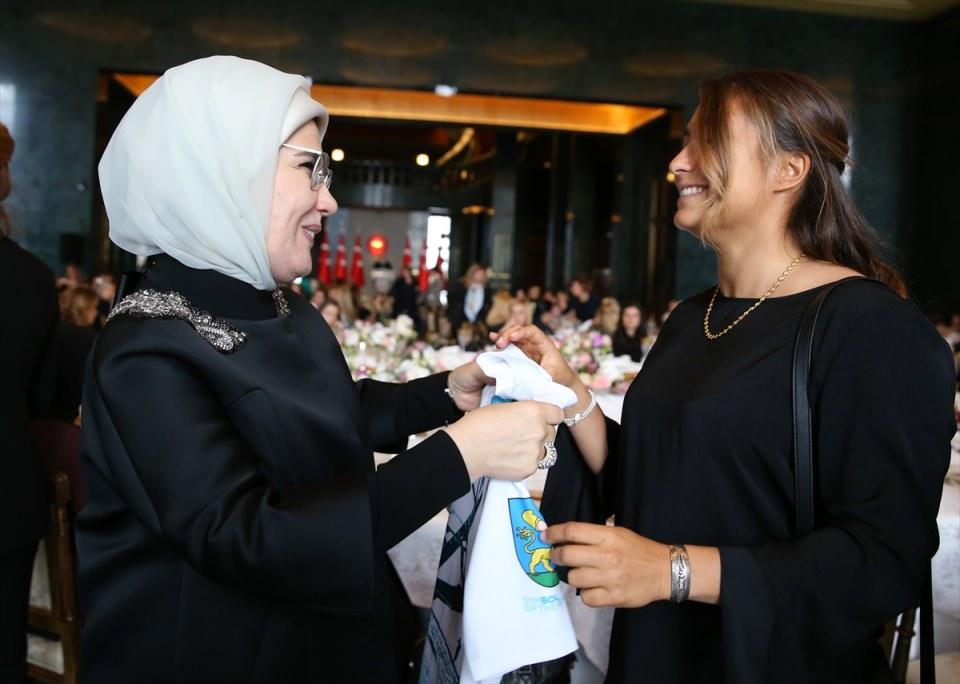 <p>Yemeğe katılan sörfçü Lena Erdil imzaladığı tişörtü Emine Erdoğan'a hediye etti.</p>