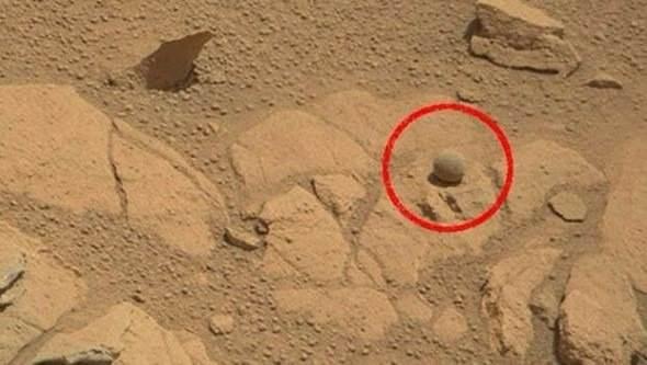 <p><strong>Mars'ta topun ne işi var? </strong></p>
<p>Curiosity’nin çektiği fotoğraflar arasında düz bir kayanın yüzeyinde, mükemmel bir küre şeklindeki bir ‘top’ görülüyor. Biraz tozlu olmakla birlikte, aslında çevresindeki diğer kayalardan farklı bir rengi olduğu da görülebiliyor.</p>
