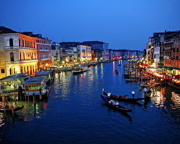 Venedik - İTALYA -  Kuzey İtalya'nın doğusunda Adriyatik denizi kıyılarında, İtalya'ya bağlı ada şehir . Karaya 4 kilometre uzunluğunda kara ve demiryolu köprüsü ile bağlanıyor. Yaklaşık 118 adacık üzerine kurulu. Venedik'te adacıkları birbirinden ayıran 170 kanal ve birbirine bağlayan 400 köprü bulunuyor. Venedik, tarih boyunca Avrupa´nın en önemli ticaret başkentlerinden biri.  Venedikliler, Türklerden ve Araplardan öğrendikleri sayı sistemi ile ticaret aritmetiğini en üst düzeye çıkarmışlar ve bu nedenle bütün Avrupalı tacirler bu aritmetiği öğrenebilmek için Venedik'te açılan birçok okula gelerek eğitim almışlar. Yaşayanların yüzde 50'den fazlası geçimlerini turizmden sağlıyor. Bu nedenle fiyatlar İtalya'nın geneline göre daha pahalı. Bütün taşımacılığın su yolları ve kanallardan yapıldığı Venedik, Avrupa'nın motorlu kara taşıtlarına izin verilmeyen tek büyük kenti. 