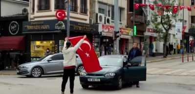 Siren sesini duydu, elindeki bayrakla caddeye koştu