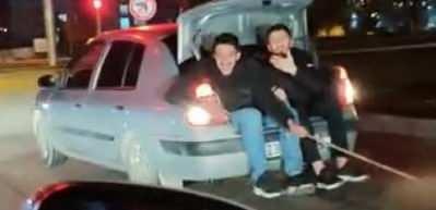 Bagaja oturup arızalanan arabayı elleriyle tuttukları iple &ccedil;ektiler